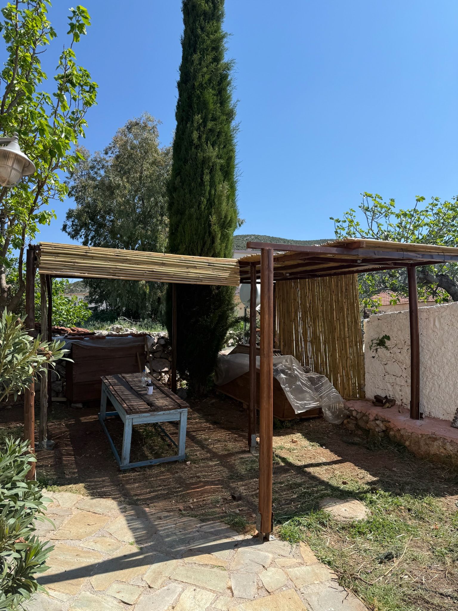 A shaded garden dining area beneath the pergola