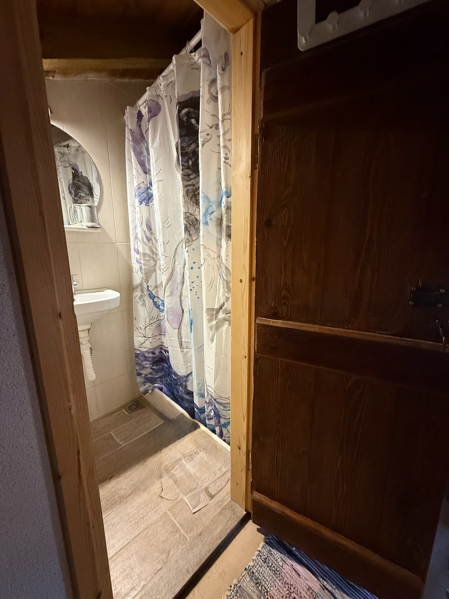 Upper-level bathroom with shower behind the timber door